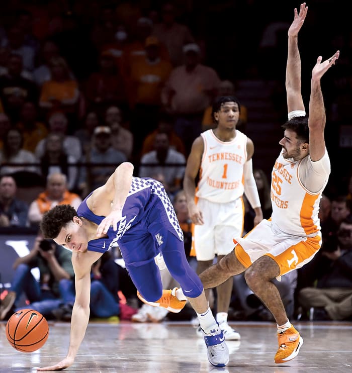 Kentucky guard Kellan Grady (31) stumbles as he is fouled by Tennessee guard Santiago Vescovi (25) during the NCAA college basketball game between the Kentucky Wildcats and Tennessee Volunteers in Knoxville, Tenn.